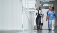 Healthcare professionals walk through a hospital corridor
