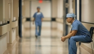 Healthcare worker sits in hospital corridor